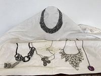 Group shot of all five necklaces laid out for full inventory