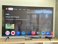 Front view showing powered-on TCL 55" TV displaying Google TV interface