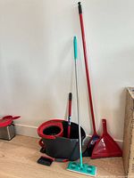 Full set leaning against wall: bucket, mop, broom, dustpan, hand brush