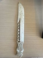 Full view of carved letter opener, blade and handle visible