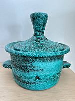 Front view of turquoise stoneware lidded pot