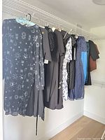 Row of nine dresses on closet rod showing variety of colours and patterns