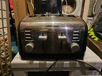 Front view of Black+Decker 4-slice toaster showing controls, slots, and cord