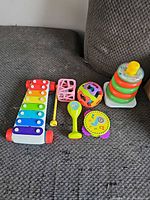 Group view of all six Fisher-Price toys laid out on sofa