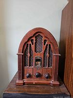 Front view of GE cathedral radio showing wood cabinet, grille, knobs, and dial