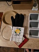 Group view of both pie plates, oven mitts, towels, storage bin, organizer tray