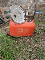Full view of orange OMC fuel tank outdoors