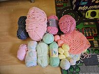 All yarn skeins and crocheted squares laid out on floor