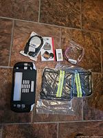 All items laid out on floor: Switch case, audio cable, blind-spot mirrors, small box, pink collar, reflective covers