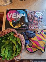 Overview of all items: board game, disco light, snuffle mat, leash, plush toy, fabric squares