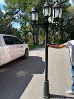 Full view of black lamp post with four lantern heads