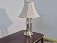 Full view of brass candlestick lamp on table