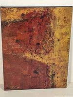 Full view of signed abstract canvas depicting warm hues and branch-like lines