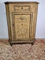 Front view of Pulaski corner chest showing floral door and drawer
