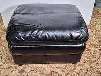 full view of rectangular black leather ottoman front and top