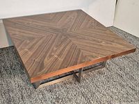 Full view of square walnut coffee table showing top and metal base