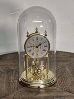 Full view of Kundo anniversary clock with glass dome