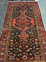 Full view of vintage Persian rug showing central medallion and border