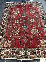 Full view of handmade Persian Tabriz wool rug showcasing red field and floral pattern