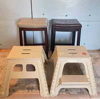 Two bar stools behind two folding step stools