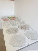 Overall view of clear and colored pressed glassware on table