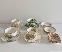 Front view of four teacup & saucer sets plus side and trinket plates
