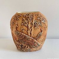 Front view showing peacock relief design and overall shape