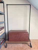 Garment rack with storage ottoman in place