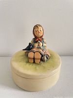 Front view of Goebel Hummel trinket box showing figurine and box body