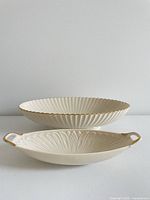 Side profile of both Lenox serving pieces stacked showing fluted design and gold trim