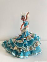 Front view of Marin Chiclana flamenco doll in turquoise floral dress