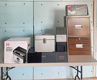 Group shot showing metal file cabinet, boxed shredder, Easy File II, metal tin and plastic file boxes