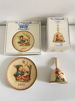 Plate and bell with their original boxes displayed