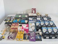 Wide view of entire lot on table showing boxed CFLs, LED bulbs, adapters