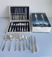 Overall lot showing flatware in case, loose serving pieces, boxed candlesticks