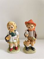 Front view of both porcelain children figurines