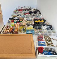 overview of entire lot from left side showing cork board, pencils, tapes, divided hardware boxes and power strips