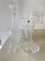 Full view of all four crystal pieces: decanter with stopper, vase with RCR sticker, bell, candy dish