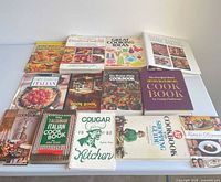 All 14 cookbooks laid out flat, full front cover view
