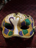 Front view of masquerade mask showing full glitter design and eye openings