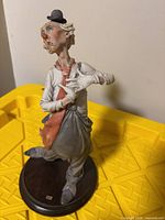 Front view of resin clown figurine on wood base