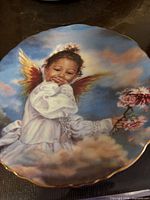 Front view of Angel of Laughter plate showing artwork, gold rim