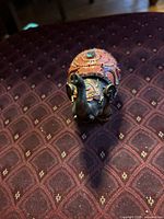 Front view of small resin elephant showing trunk and ornate saddle