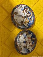 Front view of both relief musical plates showing angelic designs and coloration