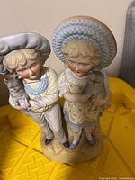 Front view of bisque figurine showing boy and girl holding kittens