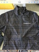 Front view of jacket showing plaid pattern and logo