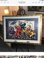 Full view of framed serigraph on easel showing entire artwork and frame