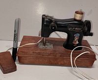 Full view of sewing machine, foot pedal, cord, spool