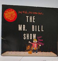 Front cover showing title, Mr. Bill figure, Saturday Night Live starburst sticker