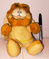 Front view of Garfield angel plush beside marker for scale